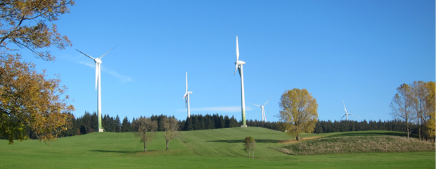 Windräder auf einer Wiese am Wald. Windräder auf einer Wiese am Wald.