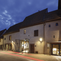 Sanierte Gebäude laden lichtdurchflutet bei Nacht zur Ausstellung ein.