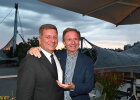 Hier sind zwei Personen auf einer Dachterrasse zu sehen: Staatsminister Christian Bernreiter und Moderator Gerd Rubenbauer. Im Hintergrund das Olympiadach