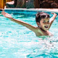 Ein Junge spielt in einem Freibad