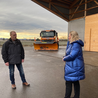 Verkehrsministerin Kerstin Schreyer und Frank Plate, Leiter der Straßenmeisterei Riem vor dem Salzlager in Sauerlach. Im Hintergrund ist ein Räumfahrzeug zu sehen. 